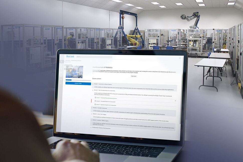 Training lab with robotic demos and a monitor showing BizLink Online Training